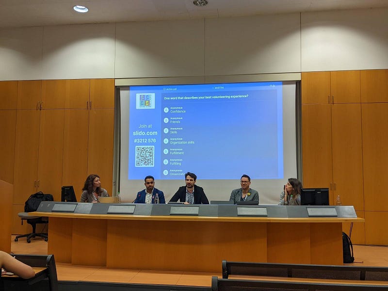 The five panelists, and in the background, a survey on volunteering experiences. Photo taken by the author.