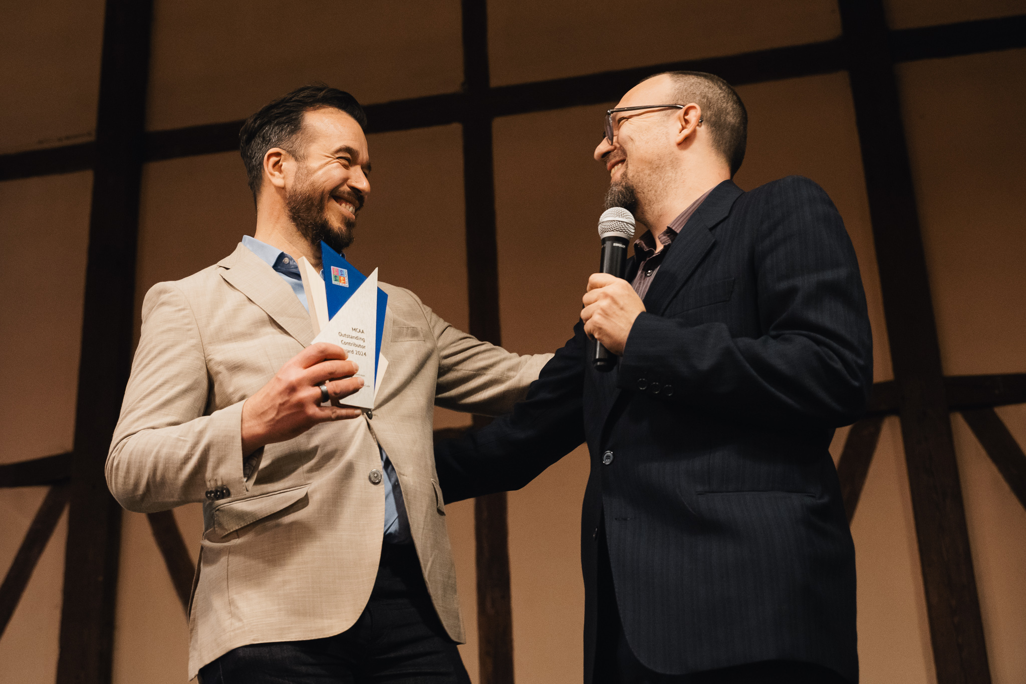 Eugenio H. Otal receiving the MCAA Outstanding Contributor Award 2024 from Gian Maria Greco, Chair of the Marie Curie Alumni Association, in recognition of his significant contributions to the MCAA community.